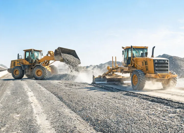 Wheel loader and grader on highway base construction site